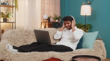 Hintli bir adam evde uzanıp, kablosuz kulaklıklı bir dizüstü bilgisayardan müzik dinliyor, ritme göre başını sallıyor. Arap adam kanepede oturuyor, en sevdiği şarkıları dinliyor, sese dalmış hissediyor.