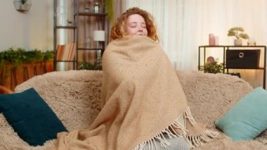 Hamile genç bir kadın yumuşak bir battaniyeye sarılmış, evinde kanepede oturur, karnına nazikçe sarılır, rahatlık ve sıcaklık hisseder. Kız, huzurlu uzayda bebekle bağ kuran sakin ve rahatlatıcı anları kucaklıyor..