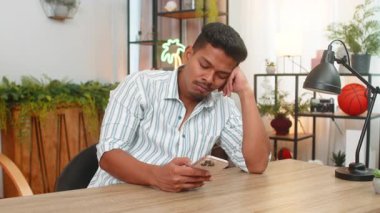 Evdeki Hintli adam akıllı telefon beslemesi sıkıcı iletileri sıkılmış ve keyifsiz görünüyor. Masadaki Arap adam ekrana bakıyor haberlerden yorgun düşüyor ve reklamlar telefonu dinlendirip sakinleştiriyor..