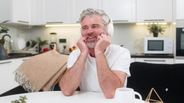 Evde orta yaşlı bir adam kablosuz kulaklıkla müzik dinliyor. Ellerine yaslanıyor, gülümsüyor ve hayaller kuruyor. Masadaki olgun adam sorumluluk almayı düşünüyor. Gelecek planı sakin ve kendinden emin..