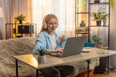 Genç bir kadın evdeki işleri yönetiyor, sıcak kahve ya da çayın tadını çıkarırken bilgisayarında kablosuz kulaklıkla yazı yazıyor. Kanepede oturan beyaz kız uzak görevleri dengeliyor, rahatlık ve verimliliği birleştiriyor.