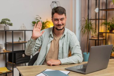Hoş geldiniz. Kafkasyalı serbest çalışan mutlu adam el sallayarak selam veriyor. Birine hoş geldin diyor. İnternet ağları, uzak mesafe sohbetleri. Ofiste dizüstü bilgisayarla oturan serbest çalışan bir adam..