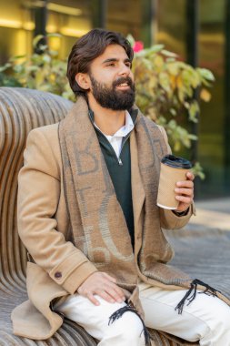 Mutlu Hintli genç adam sabah kahvesinin tadını çıkarıyor sıcak içecek ve dışarıda gülümsüyor. Dinleniyorum, ara veriyorum. Lübnanlı bir adam şehir merkezindeki sokakta oturmuş kahve içiyor. Kasaba yaşam tarzları