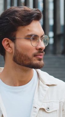 Mutlu Hintli genç bir adamın portresi güler yüzlü, kameraya bakan mutlu yüz hayal kuran, dinlenen rahatlayan, dışarıda iyi haberler veren. Şehirdeki Arap Hindu adam. İş adamları