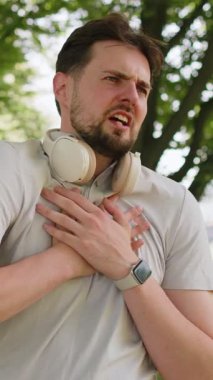 Genç yetişkin sporcu koşucu, şehir parkında çalıştıktan sonra kalp krizi ya da göğüs ağrısı çekiyor. Yorgun bir sporcu kalbindeki gerilimden muzdariptir. Sağlık ve spor konsepti.