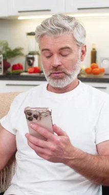 Evde orta yaşlı bir adam akıllı telefondan yapılan ödemeyi onaylıyor. Banka çekleri de onaylıyor. Kanepedeki olgun adam ekranda fişi görüyor. Gülümsüyor. Kolay nefes alıyor..