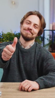 Gibi. Mutlu, heyecanlı, beyaz bir adam kameraya bakıp olumlu bir işaret veriyor. İyi haber, olumlu geri bildirim. Genç sakallı adam evdeki ofis masasında oturuyor.