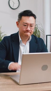 Laptop üzerinde çalışırken asyalı sinirli iş adamı, beklenmedik internet sitesi problemi, bilgisayar virüsü veri kaybı hackleme. Freelancer ofisteki kırık defter yüzünden kızgın.