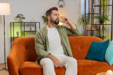 Tatmin olmuş beyaz tenli bir adam evinde, kanepede oturup sağlıklı bir hayat sürüyor, bir bardak saf su içiyor, gülümsüyor. Her gün su iç. Odadaki adam kameraya gülümsüyor..