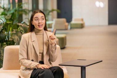 Evreka. Düşünceli, zeki, ilham verici, beyaz bir kadın parmağını kaldırarak yaratıcı bir plan yaptı. Otel lobisindeki ilham verici soruyla heyecanlandı. Kız koridorda oturuyor.