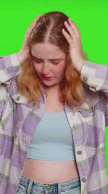 Duymak istemiyorum, dinle, sessiz ol. Sinirli, sinirli, kulaklarını tıkayan, hayır diyen, tavsiyelerden kaçan, gürültülü sesleri görmezden gelen bir kadın. Kızıl saçlı kız krom anahtar arka planında izole edilmiş.