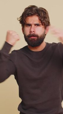 Ciddi bir Hindu öfkeli genç adamın portresi dövüş hareketi göstererek avucuna yumruk atıyor. Uzun kollu sakallı Lübnanlı adam rakibine saldırmaya hazır. Hintli İspanyol çocuk bej arka planda tek başına