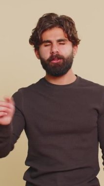 Kimseye bir şey söylemeyeceğim. Korkmuş Lübnanlı genç adam elleriyle ağzını kapatıyor, kameraya korkmuş bakıyor, jestler yapıyor, bej arka planda korkunç bir sırrı söylemeyi reddediyor.