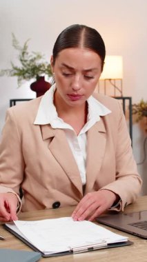 Merkez ofisteki genç iş kadını raporda hata buldu yırtık kağıtları yeni bir belgeyi açtı ve planı sıfırladı. Masa başındaki serbest çalışan kız dizüstü bilgisayarda hızlı çalışıyor, metin kaydetme dosyasını düzeltiyor ve çalışma firmasına devam ediyor