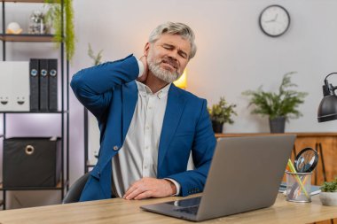 Merkez ofisteki orta yaşlı işadamı aniden boğazını sıkıyor. Derin bir acı hissediyor. Acilen rahatlaması gerekiyor. Masadaki serbest çalışan adam kaslarını esnetiyor. Rahatsızlık geçsin diye masaj yapıyor..