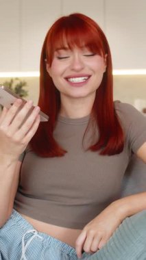 Evdeki genç kadın akıllı telefon hoparlörünü açar sıcak konuşmaya başlar el hareketlerini, gülümsemeleri ve başını sallamaları kullanır. Kanepedeki kızıl saçlı kız olumlu ses tonunu seviyor. Mutlu sohbetler, anlamlı eller ve sevinçle..