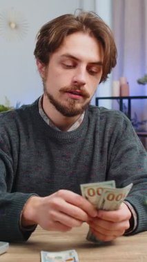 Planlama bütçesi. Zengin ve mutlu bir adam para sayıyor dizüstü bilgisayar kullanıyor ev işleri masasında faturaları hesaplıyor. Beyaz adam gelir kazancından memnun, planlı tatil hediyeleri için para