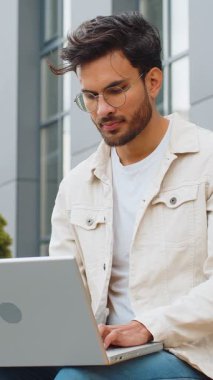 Dizüstü bilgisayarda çalışan mutlu Hintli genç adam mesajlar gönderiyor, online alışverişler yapıyor, film izliyor, açık havada e-posta okuyor. Sokak bankında oturan Arap Hindu adam. İş adamları