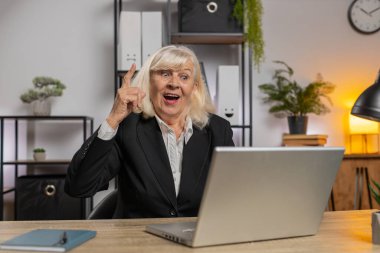 Modern ofis çalışma masasında çalışan, işine odaklanmış, bağımsız bir iş kadını. Not defterine fikirler yazıyor. Resmi takım elbiseli kız büyükanne planlama başlatma projesi hazırlıyor.