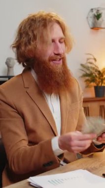 Heyecanlı beyaz sakallı iş adamı nakit para sayıyor maaşını kontrol ediyor modern işyerindeki zenginliğin tadını çıkarıyor. Merkez ofisteki para birikimlerini hesaplayan mutlu serbest çalışan adam..