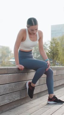 Şehir parkında diz ağrısı olan genç bir bayan. Masaj yapan bir kadın, dışarıda koşarken travma yaralanması. Fitness dişisinin burkulması şiddetli ağrı germe kuvveti. Bacağa kramp giren baldır sporu.