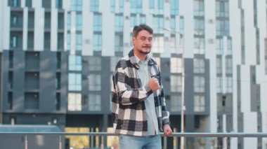 Kafkasyalı yetişkin bir adam şaşırmış görünüyor. Aniden kazanılan galibiyeti kutluyor. Piyango golü başarısını kutluyor. Şehir merkezinde yumruk sallayan heyecanlı adam..