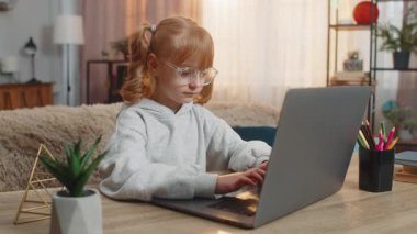 Dizüstü bilgisayara bakan, klavye yazan genç bir kız büyük bir hevesle çevrimiçi programlamayı öğreniyor. Çocuk, olumlu sonuç elde ettikten sonra heyecan içinde eğitim çalışmasında ilerleme kaydederek kutluyor