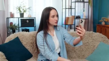 Evde oturan genç bir kadın, sinirli ve duygusal olarak video görüşmesi için tartışıyor, öfkeyle el sallıyor. Kafkasyalı kız hayal kırıklığı, çatışma, anlaşmazlık ve duygularını ifade ediyor. Tartışma!