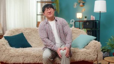 Evdeki Asyalı adam dizini kavrıyor, hareket keskin bir rahatsızlığı tetiklerken acı dolu yüzüyle eklem masajı yapıyor. Çinli adam gerginlik endişesini iletiyor, ağrıyan bacağından kurtulmak için, hareket kabiliyeti mücadelesi veriyor..