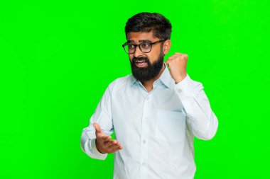 Hintli bir adam kararlı bir ifadeyle yumruğu avucunun içine atar. Hazırlığı ve harekete geçme dürtüsünü simgeler. Arap adam krom anahtar arka planda izole edilmiş. Güçlü bir kendinden emin hareket gösteriyor.