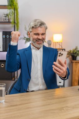 Merkez ofisteki orta yaşlı işadamı elinde akıllı telefonuyla piyango bileti okuyor büyük ikramiye kazanıp kutlama yapıyor. Masadaki serbest çalışan adam zafer yumruğunu kaldırdı. Gülümsüyordu. Heyecanla gelecekteki hedeflerini planlıyordu..