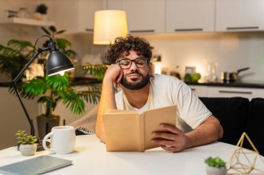 Evdeki Arap adam sıkıcı kitap okuyor. Gözleri ağır ağır uzanıyor. Yavaş yavaş sayfaları sıkılıyor. Masada oturan Mısırlı adam bölümü bitirmek için okumaya devam ediyor.