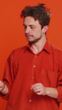 Sihirbaz, sihirli değnek ve sihirli değnekle el kol hareketi yapan yakışıklı adam dileği gerçekleştiren sihirbaz reklam indirimi yapıyor. Kafkas sakallı adam turuncu arka planda izole edilmiş.