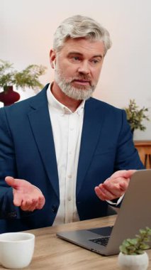 Merkez ofiste kulaklık takan orta yaşlı bir işadamı çağrı merkezi oturumunda gülümseyen bir çağrı hattına cevap veriyor. Masadaki serbest çalışan adam müşteri memnuniyetini arttırmak için kısa tavsiyeler veriyor..