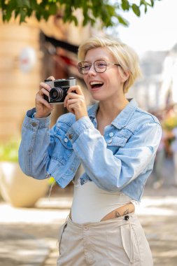 Kafkas genç bayan turist hafta sonları şehir merkezini geziyor, dışarıda antika kameralarda fotoğraf çekiyor. Şehir caddesinde mutlu sarışın kız gezgin sürprizi. Yaşam Tarzları.