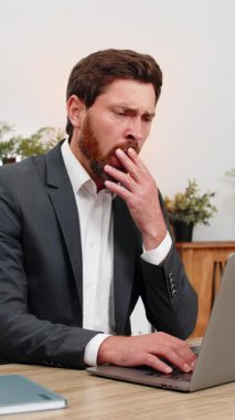 Merkez ofisteki orta yaşlı işadamları dizüstü bilgisayarda uyukluyorlar ve el üstünde uyukluyorlar. Masadaki serbest çalışan adam dövüşüyor. Yorgunluk yavaş yanıp sönüyor ve neredeyse uyuyor. Sonra tekrar işe dönüyor..