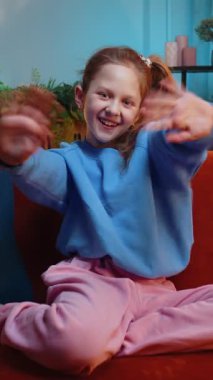 Kameraya gülümseyen ve el sallayan genç kız merhaba, merhaba, merhaba ya da güle güle diyerek misafirperver bir yüz ifadesiyle karşıladı. Genç bir çocuk akşam evde, oturma odasında kanepede oturuyor.