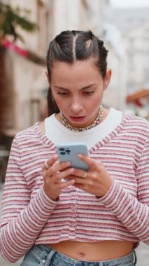 Akıllı telefon daktilosu kullanan genç bir kadın aniden piyango şokunu kaybeder. Kötü haber kaybı uygulaması başarısız virüs hırsızlığı. Şehir sokağında duran üzgün turist kız..