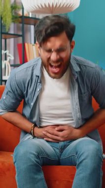 Hintli genç adam kanepeye oturur ve karın ağrısı, mide iltihabı gibi ani ağrılar hisseder. Sakallı Arap adam ishal, hazımsızlık, peptik ülser ve pankreas zehirlenmesi geçiriyor.