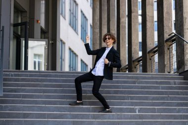 Dans, başarı ya da iş görüşmesi, terfi ya da kurumsal anlaşmadan sonra yürüyen adımlarla kutlama yapan iş adamı. Heyecanlı ya da mutlu dans çalışanı şehir merkezindeki satış hedeflerini ya da hedeflerini kutluyor.