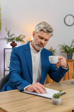 Merkez ofisteki orta yaşlı işadamı kahve aromasını yudumlarken kendini yenilenmiş hissediyor. Masa düzenleme bölümündeki serbest çalışan adam rapora çizelge numaraları ekleyerek kesinlik ve netlik sağlıyor.