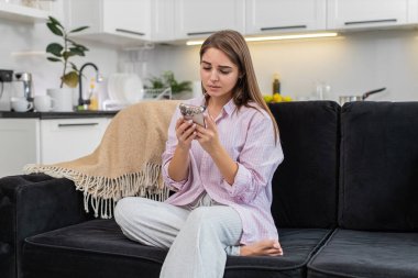 Evde akıllı telefon tutan genç bir kadın maçı kaybettikten ve işten atıldıktan sonra sonuçları okuyor ve iç çekiyor. Kanepedeki beyaz kız alnına dokunuyor, başını sallıyor üzgün bir tepki göstermiyor hayal kırıklığına uğramış ruh hali ve stres.