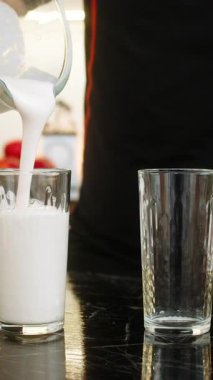 Adam sağlıklı beslenme için mutfak tezgahının üzerine protein içeceğini karıştırıcıdan cama döküyor. Muz sütü süzme peyniri ve süt proteini ile sallamak kas düzeltme ağırlık kontrol spor salonunu destekler.