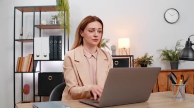 Merkez ofisteki orta yaşlı bir iş kadını diz üstü bilgisayarda el pençe divan duruyor. Onaylanma umutlarına bakıyor. Masadaki serbest çalışan kız cevap bekliyor. Gelen kutusunu kontrol ediyor. Not yazıyor.