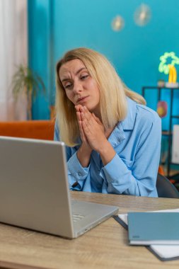 Gergin kadın serbest çalışan dizüstü bilgisayarın web kamerasında elleri bağlı vazifesini tamamlamak için daha fazla zaman istiyor. Genç iş kadını kadın çalışan video görüşmesi sırasında masa başı iş talebinde bulundu..