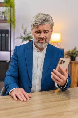 Merkez ofisteki orta yaşlı işadamı akıllı telefon okuma projesine bakıyor. Başarısızlık uyarısı derin umutsuzluk içinde nefes alıyor. Masadaki serbest çalışan adam üzüntülü bir şekilde iç çekiyor. Bir sonraki çalışma adımını planlarken yığılmış durumda..