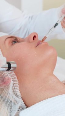 Enjeksiyonsuz mezoterapi ya da elektroporasyon. Güzellik doktoru müşteriyi genç yetişkin bir kadına güzellik salonunda terapi yaptırıyor. Kız cilt bakımı anti-yaş spa prosedürü kapalı alan estetik kozmetolojisi