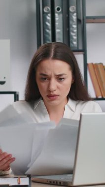 Stresli genç iş kadını ödenmemiş banka borçlarına bakıyor, evrak işleriyle uğraşıyor, bütçe planlıyor, ev kredisi ödemelerini hesaplıyor. Serbest çalışan hoşnutsuz kadın kağıt para fırlatıyor.