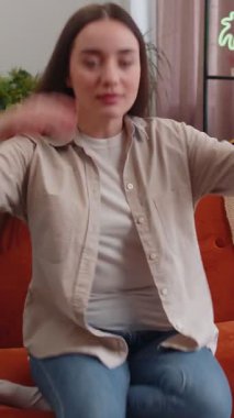 Yorgun genç bir kadının portresi evdeki kanepede dinlenmenin keyfini çıkarıyor. Mutlu güzel bayan kanepede dinleniyor yorucu bir günün ardından kestiriyor, gözlerini kapatıyor, ellerini başının arkasına koyuyor, stresten kurtuluyor, dinleniyor.