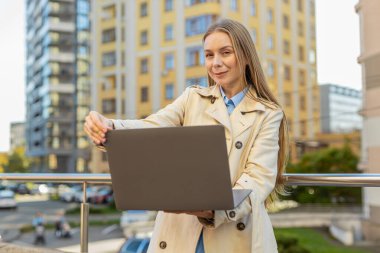 Beyaz kadın serbest çalışan, şehir merkezindeki internet sitesinde bilgisayarla çalışıyor ve tatilde internette sohbet ediyor. Netbook ekranı kullanan mutlu kız film izleyen mesajlar gönderiyor.